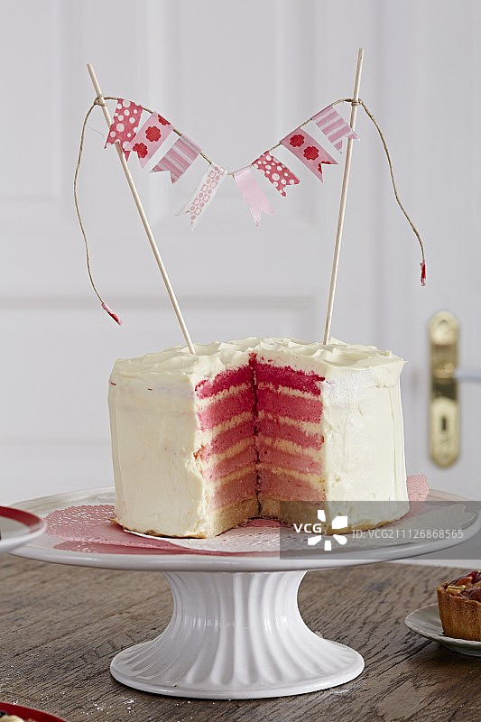 粉色彩虹蛋糕切片，在蛋糕架上图片素材