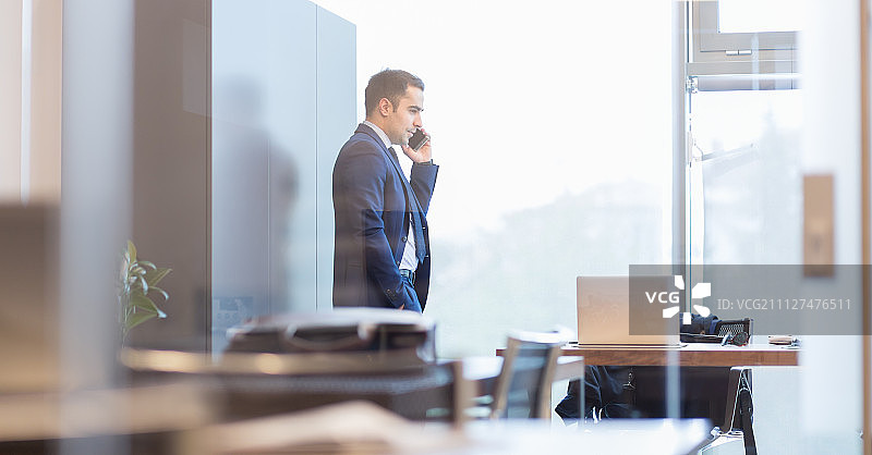 商人打电话望着窗外图片素材