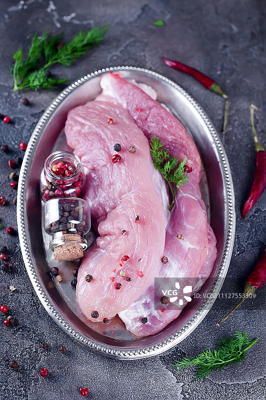 铁盘上撒有调味料的鲜嫩生里脊肉，准备烘烤图片素材