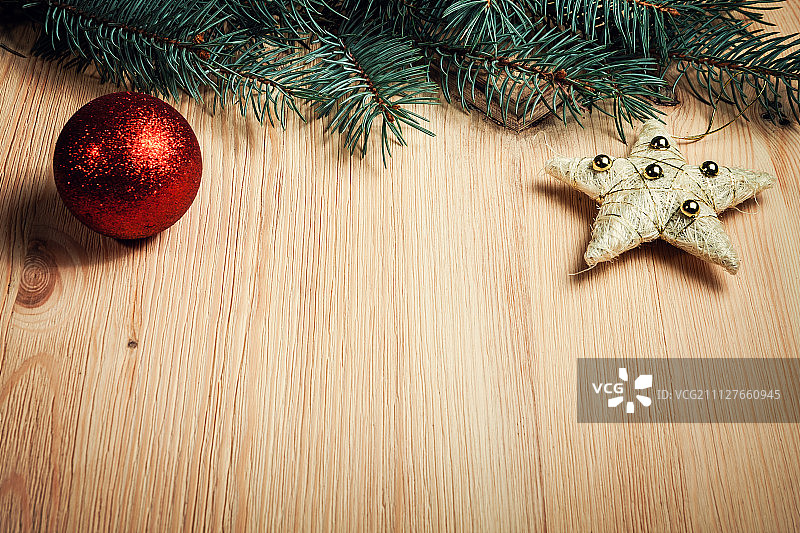 带有冷杉树和红色小饰品的圣诞木质背景图片素材