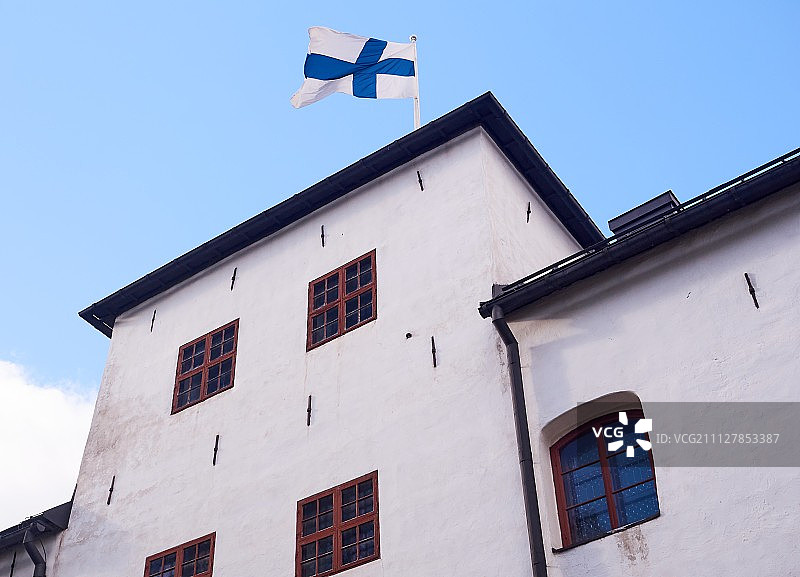 阳光明媚的芬兰土尔库城堡屋顶上的芬兰国旗图片素材
