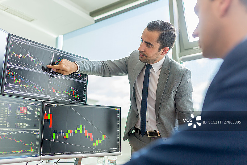 股票经纪人观看电脑屏幕进行在线交易图片素材
