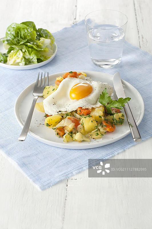 土豆、胡萝卜和韭葱烩，配煎蛋和蔬菜沙拉图片素材
