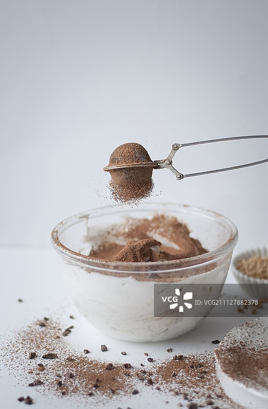将可可粉筛入巧克力酥皮混合物中图片素材
