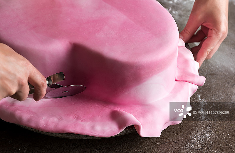 在面包店装饰心形婚礼蛋糕的女人图片素材