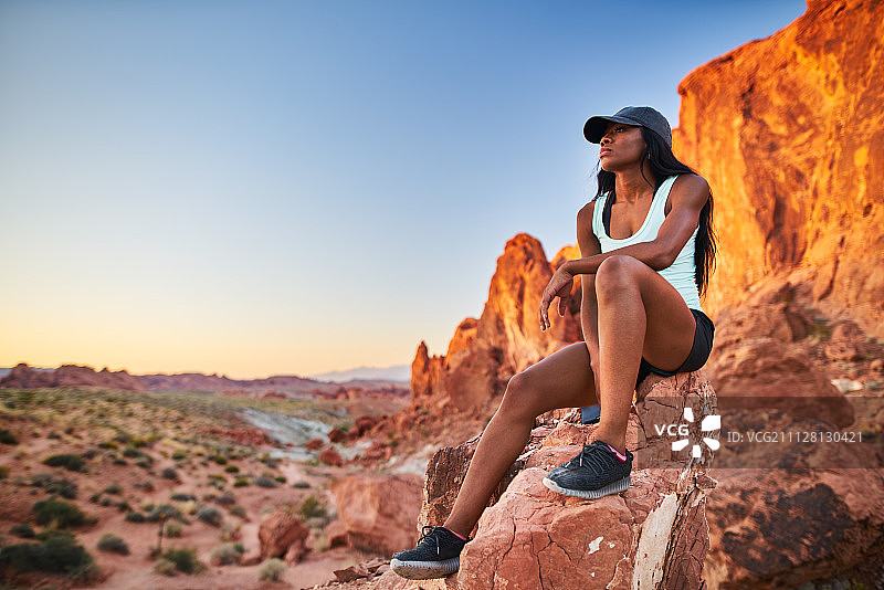非裔美国女性在火焰谷公园的岩石上休息图片素材