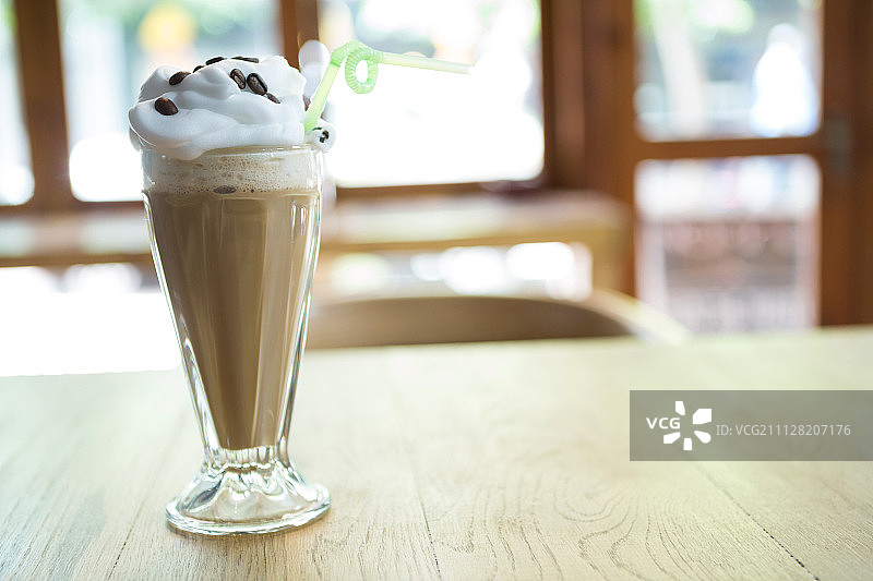 咖啡馆木桌上带奶油的巧克力奶昔图片素材