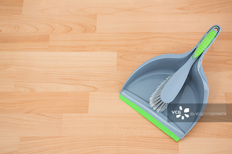 硬木地板上带簸箕的灰色刷子的俯视照片图片素材