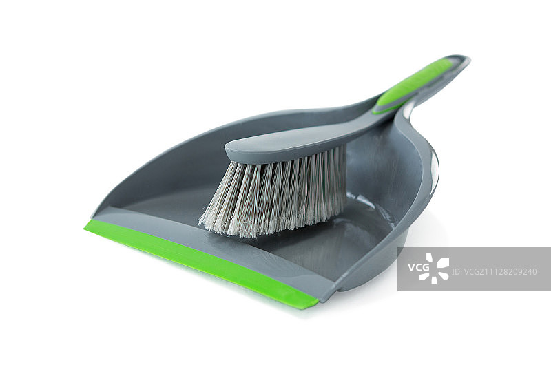 白色背景下的灰色簸箕和刷子特写图片素材