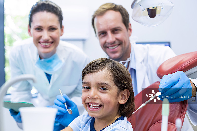 牙医在牙科诊所用工具检查年轻患者的肖像图片素材