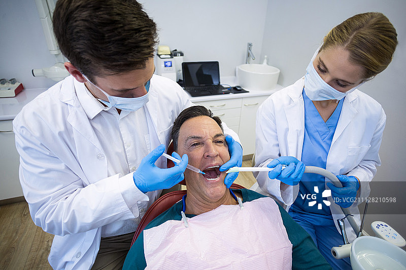 牙医在诊所给男病人麻醉图片素材