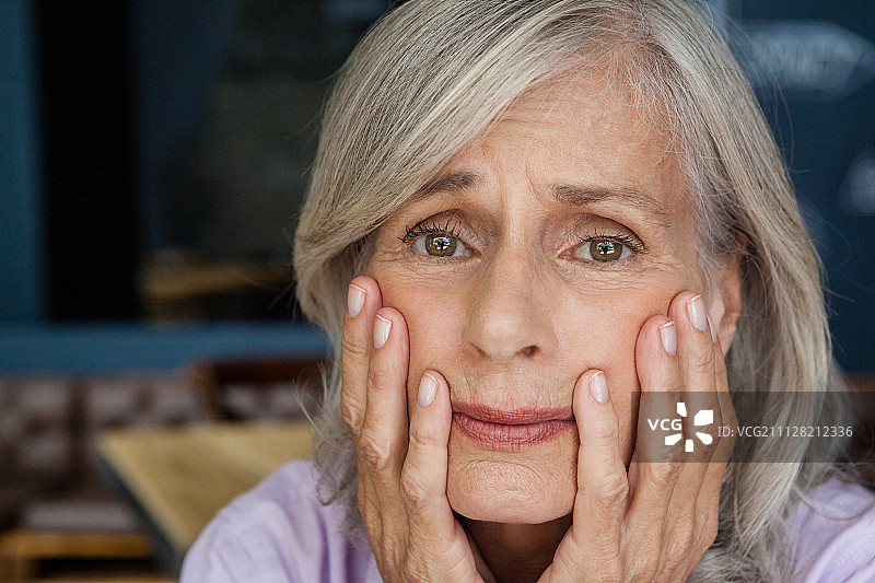 咖啡店里忧心忡忡的老年妇女肖像图片素材