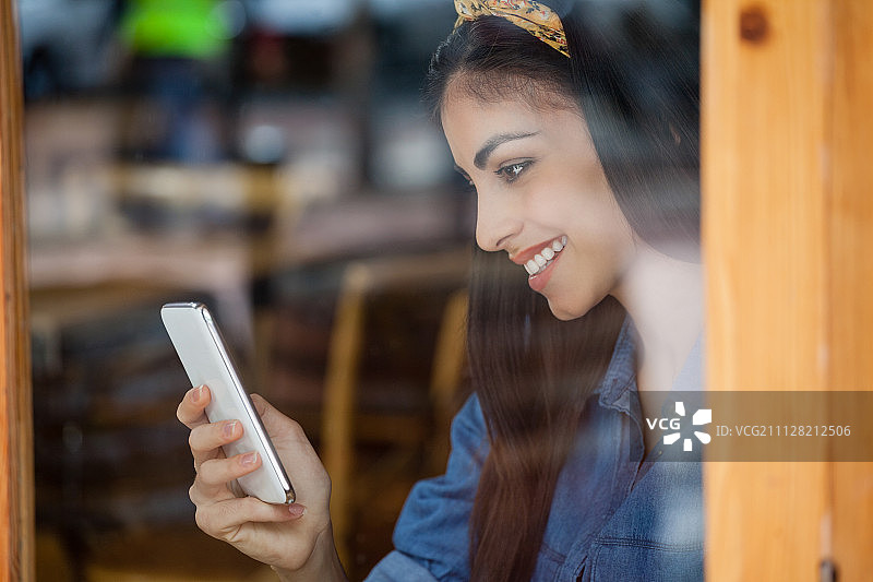 微笑的女人在咖啡馆使用手机图片素材