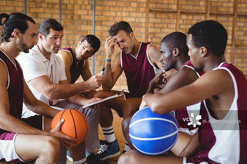 教练在球场上向篮球运动员讲解比赛计划图片素材