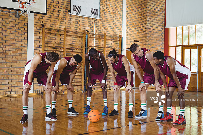 疲惫的篮球运动员在篮球场上休息图片素材