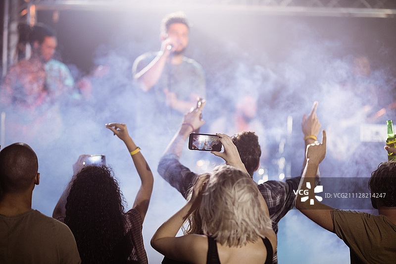 在夜总会欣赏音乐会的粉丝的背影图片素材
