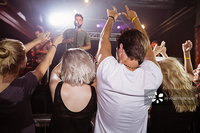 音乐节夜店里举手欢呼的粉丝背影图片素材