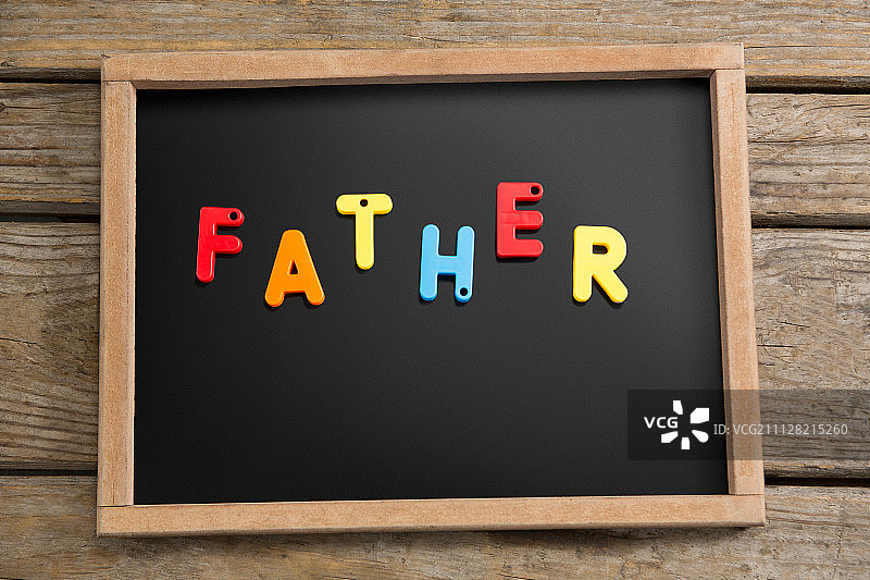 木桌上写有“父亲”字样的石板俯视图图片素材