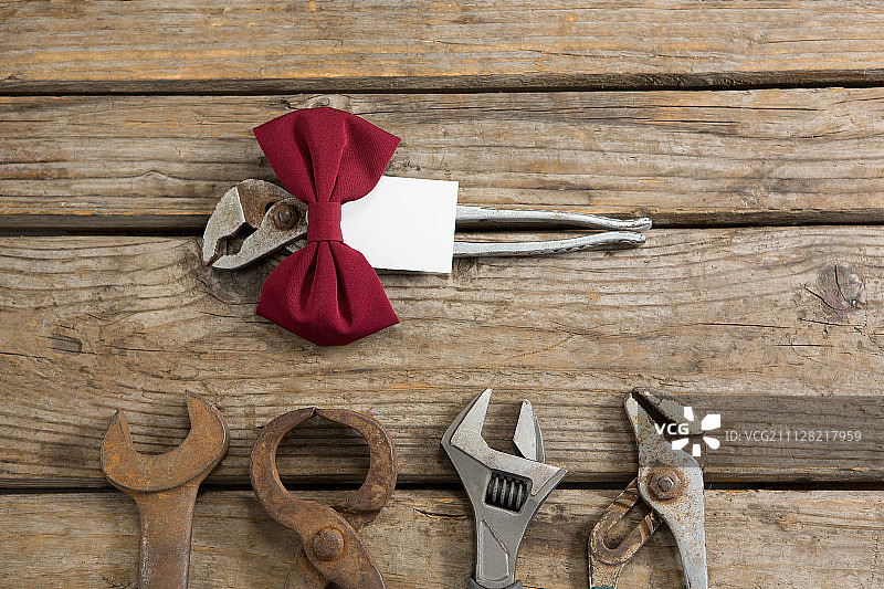 带领结的工作工具在木桌上的俯视图图片素材