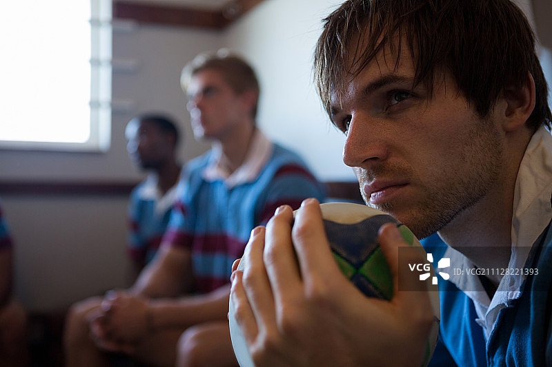 在更衣室与团队坐在一起的沉思球员特写图片素材