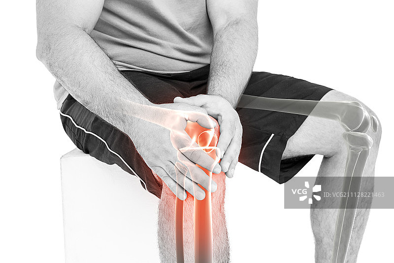 男人坐在白色背景前，手扶着酸痛膝盖的腰部特写图片素材