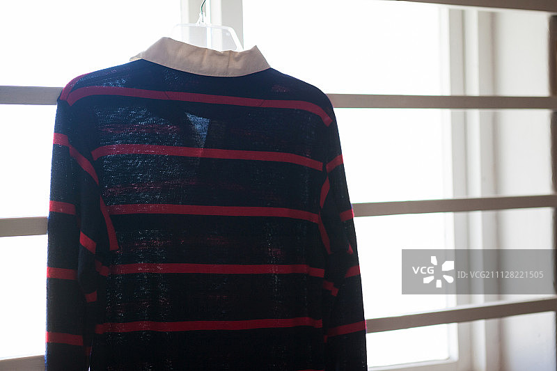 阳光明媚的一天，挂在窗户上的橄榄球衫特写图片素材