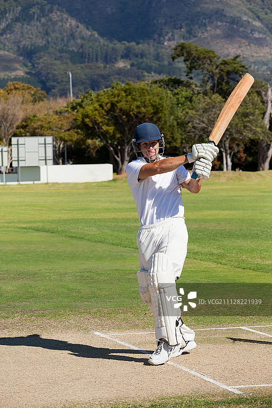 阳光明媚的日子里在球场上打板球的年轻击球手图片素材