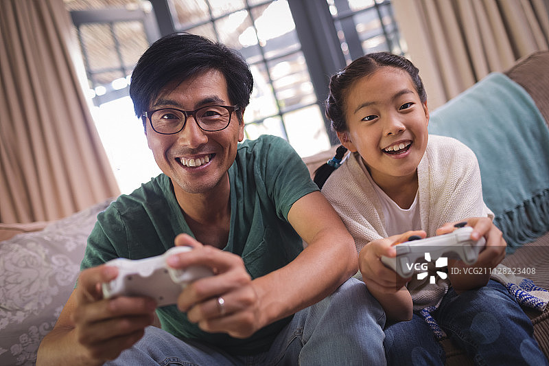 父女在家里的客厅玩电子游戏图片素材