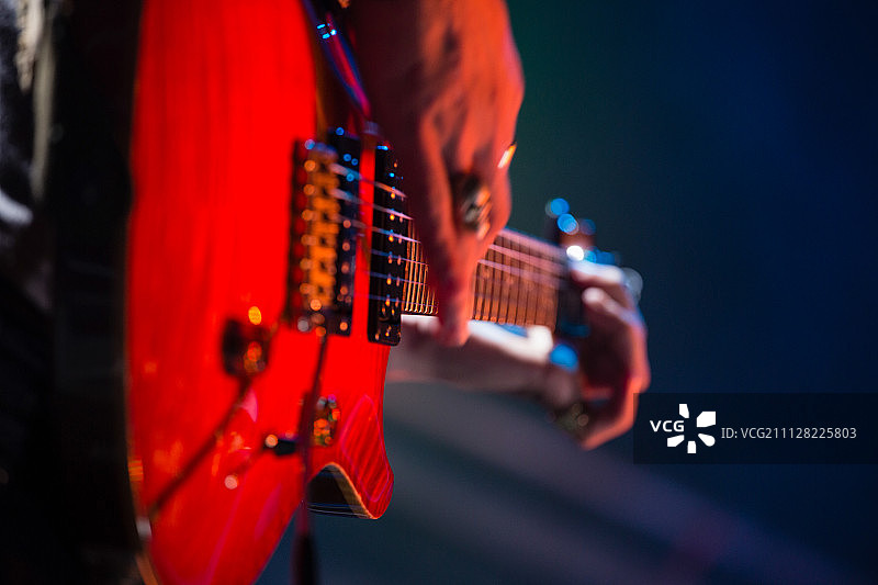 在夜总会舞台上弹吉他的吉他手特写图片素材