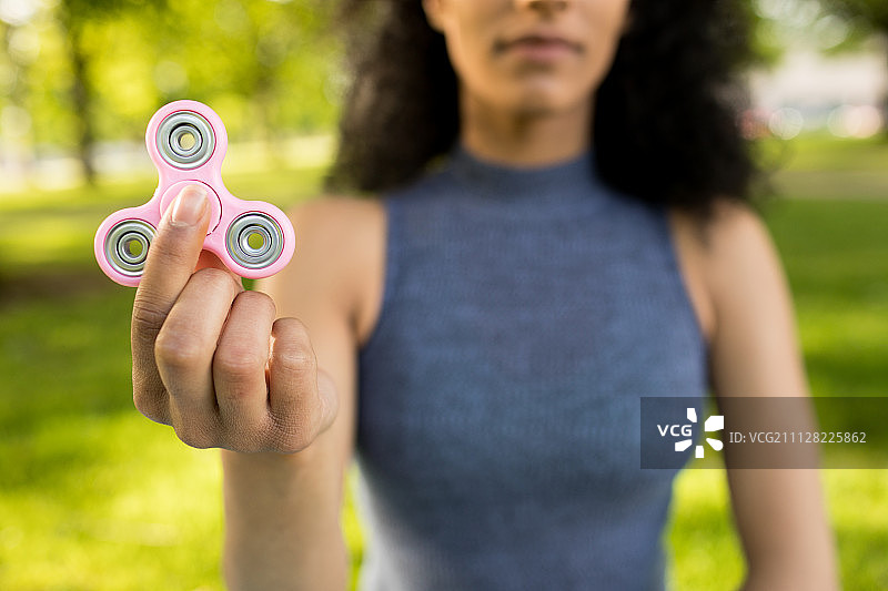 女孩在公园里玩指尖陀螺特写图片素材