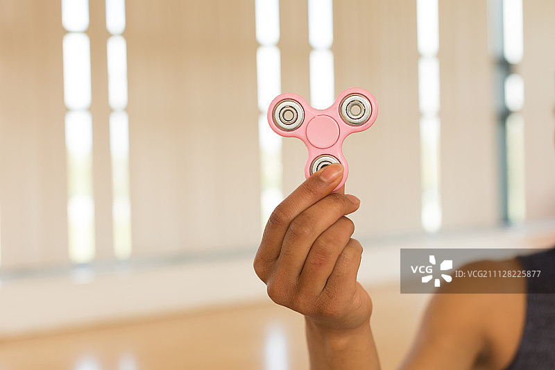 健身房里拿着指尖陀螺的女孩的手特写图片素材