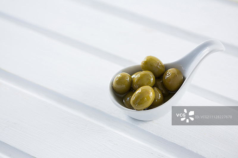 特写：勺子里的腌制青橄榄图片素材