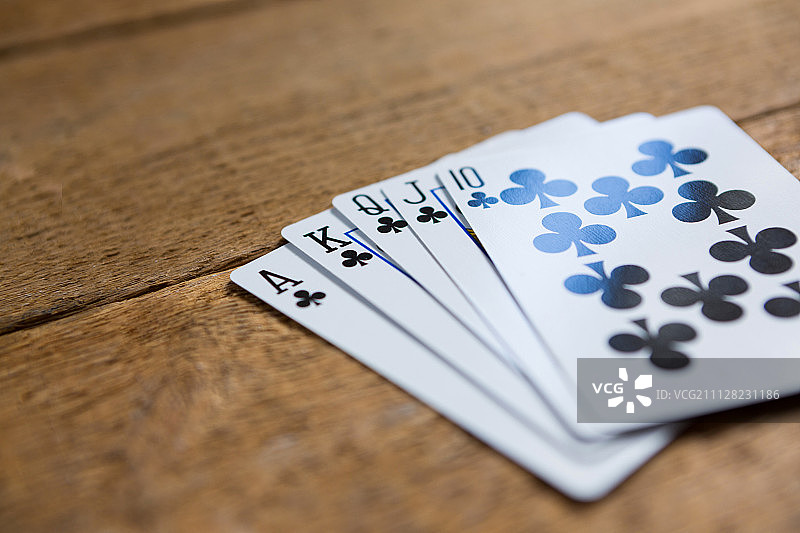 赌场木桌上的梅花扑克牌特写图片素材