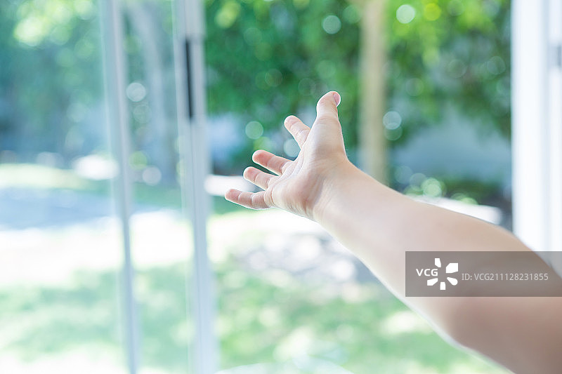 在家中手伸向窗户的局部照片图片素材