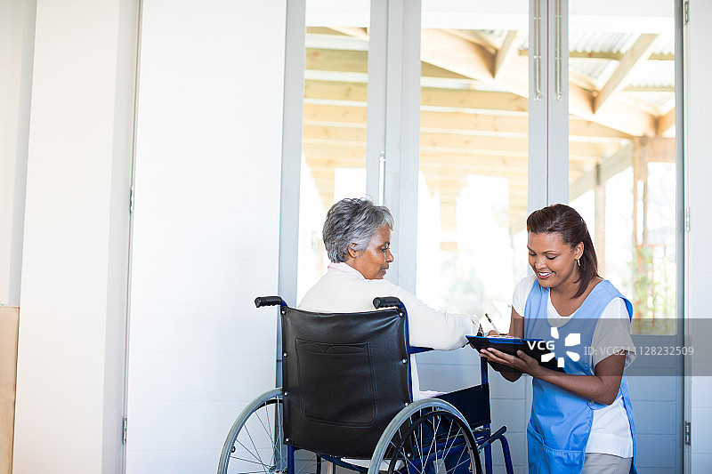在家与女医生讨论的残疾老年妇女图片素材
