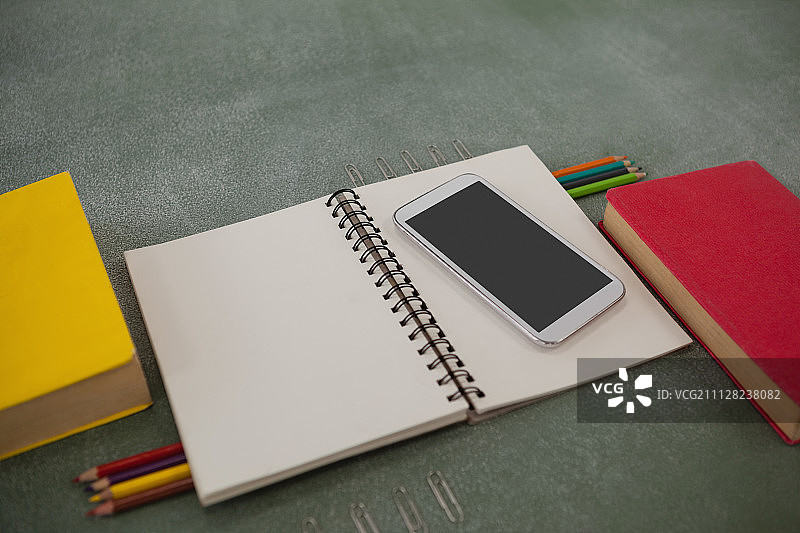 黑板上排列的各种学习用品和手机近景图片素材