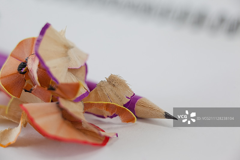 铅笔和卷笔刀屑在书本上的特写图片素材