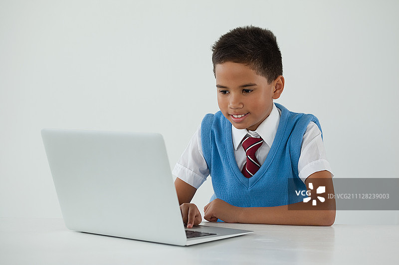 在白色背景下使用笔记本电脑的男学生图片素材