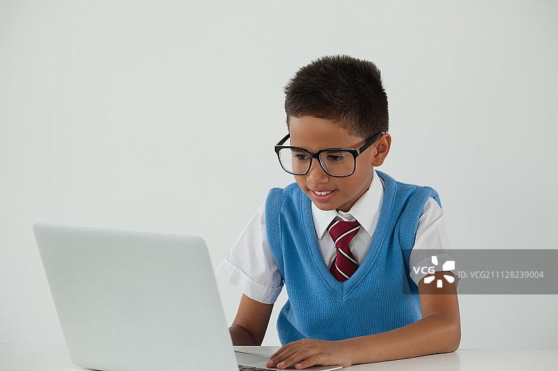 在白色背景下使用笔记本电脑的男学生图片素材