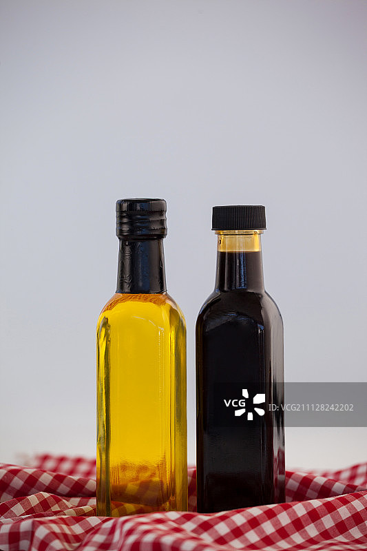 餐巾上瓶装绿色和黑色橄榄油特写图片素材
