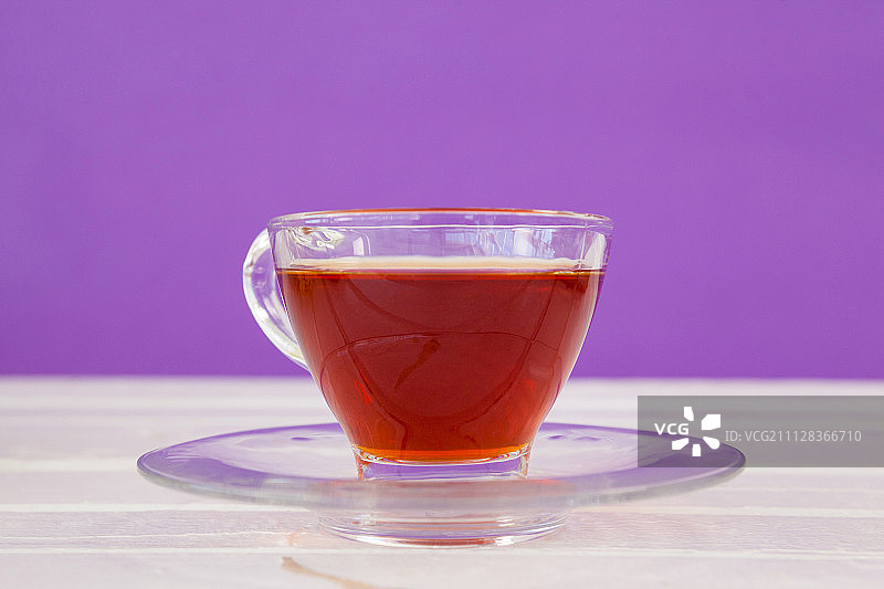 白色桌子上紫色背景下的草药茶图片素材