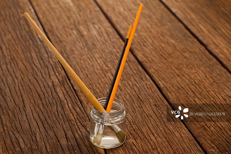 装满水的罐子里的画笔，白色背景图片素材