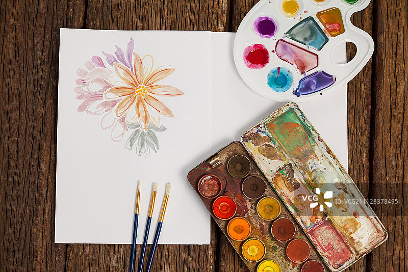 木桌上的调色板、画笔和白色纸张图片素材