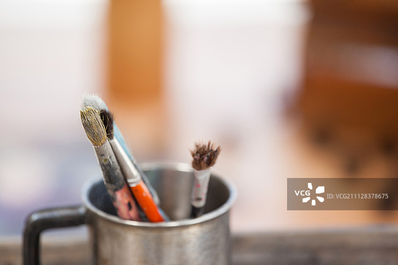 木桌上杯子里的画笔套装图片素材