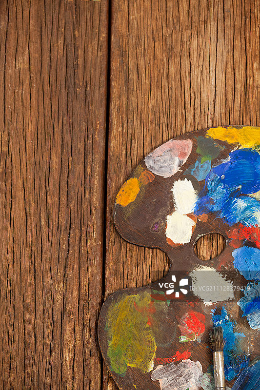 木桌上的多色颜料和画笔调色板图片素材