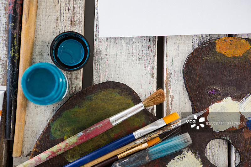 木质表面上的水彩颜料、调色板和画笔特写图片素材
