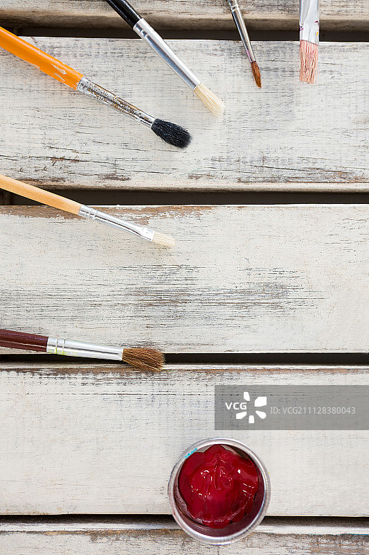 排列在木质表面上的各种画笔和水彩图片素材