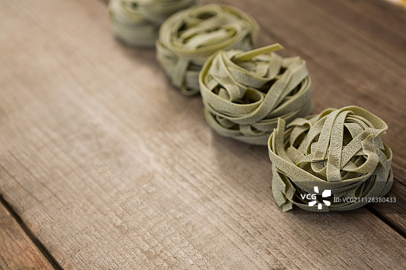 木质背景上排列成行的意式宽面图片素材