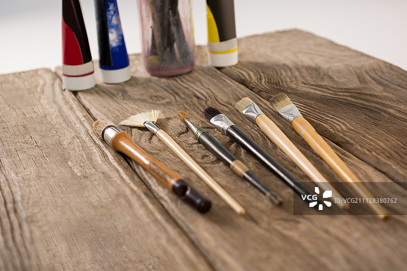 排列在木质表面的画笔和水彩颜料图片素材