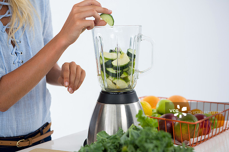 女人准备白色背景下的蔬菜冰沙图片素材